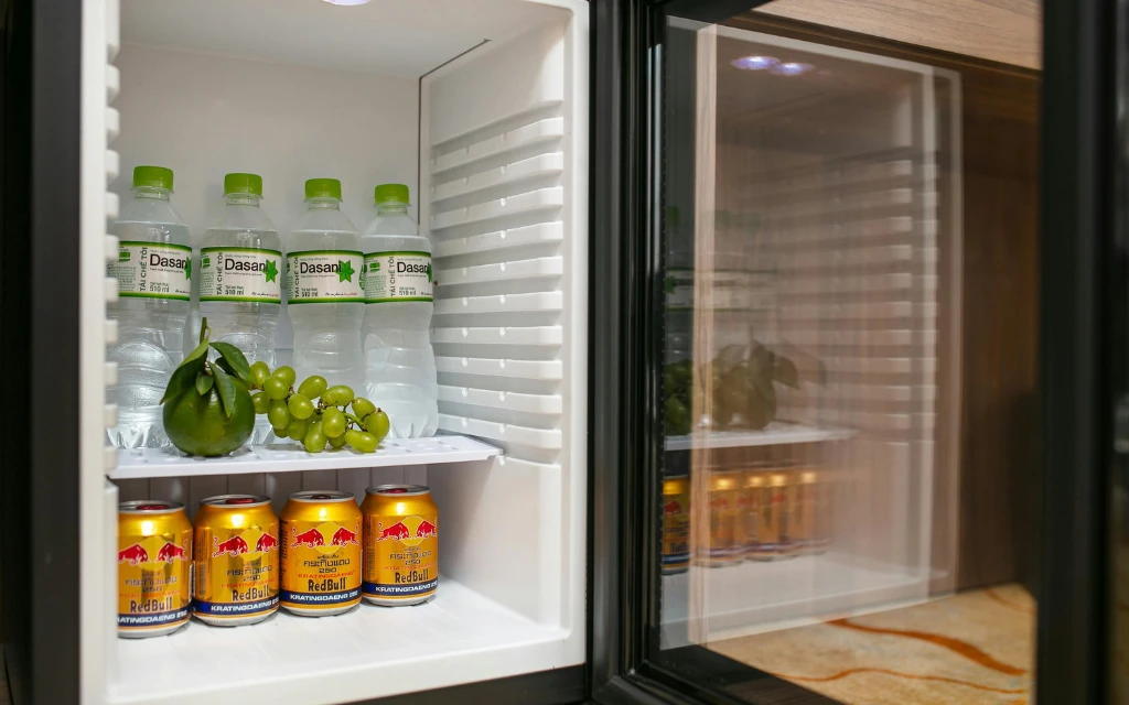a refrigerator with a shelf full of drinks and fruit